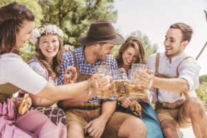 Freunde in trachtenmode entschpannen an der Isar